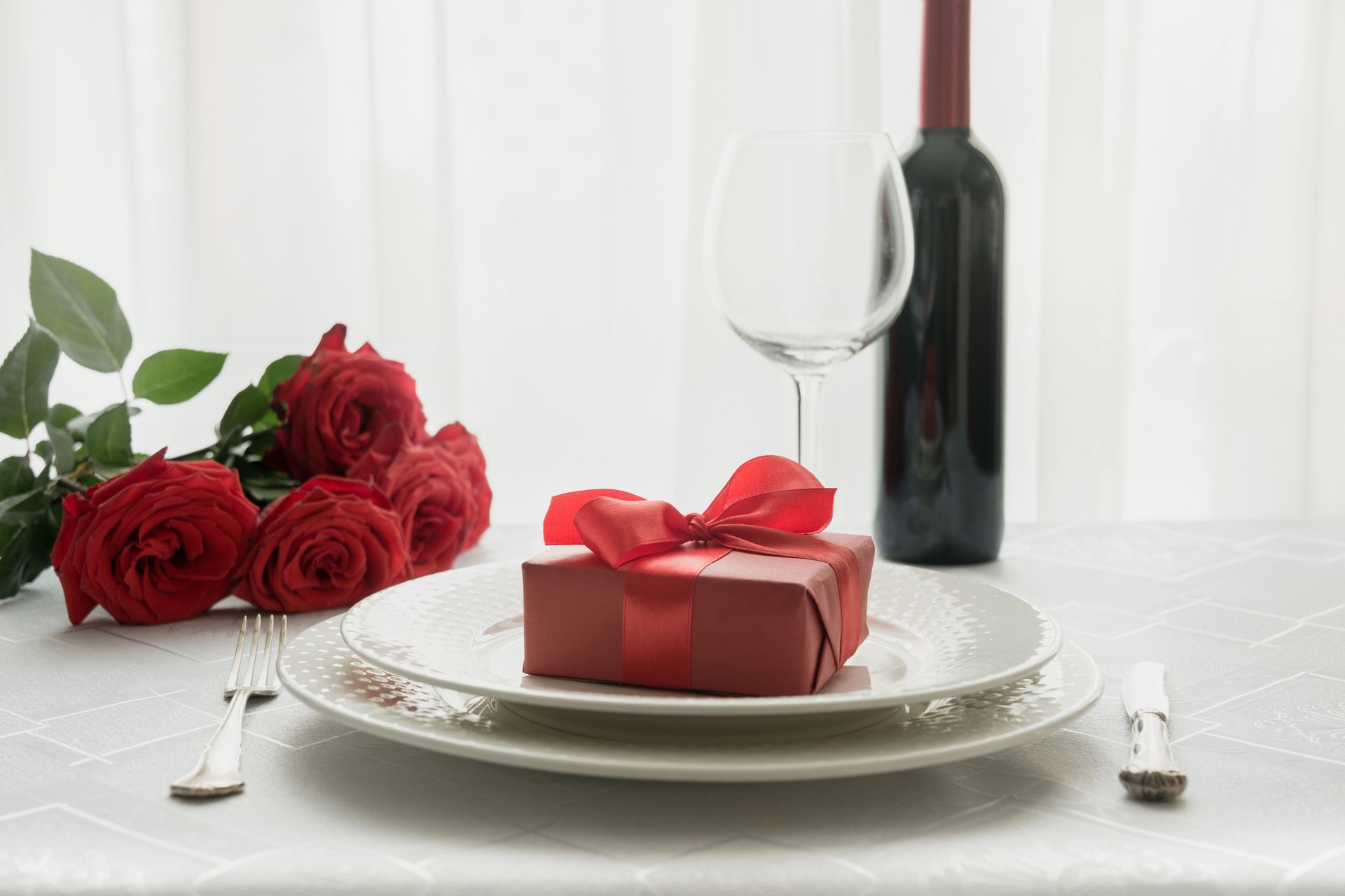 Réglage romantique de place de table avec des roses rouges de bouquet. Espace pour le texte. Invitation à la date. La Saint-Valentin.